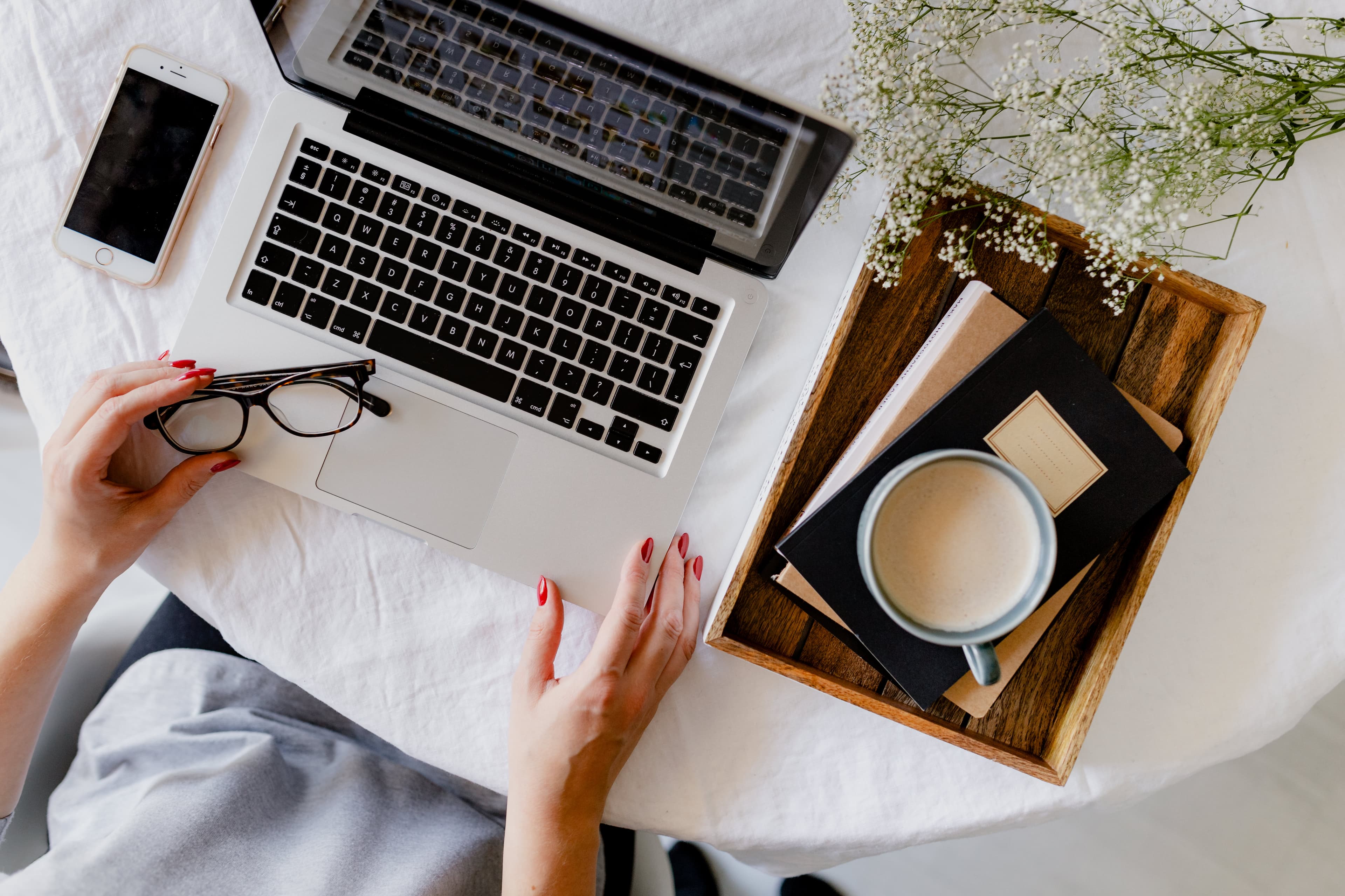 A woman working at a desk with a laptop and a cup of coffee.